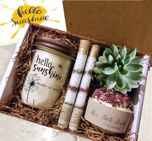 Load image into Gallery viewer, Box of Sunshine to brighten her day!! - A gift box containing a jar candle with "happy birthday" written on it, two tubes of bath salts, a bath bomb labeled "Rose" with dried petals, and a small green succulent plant, all nestled in brown shredded paper.