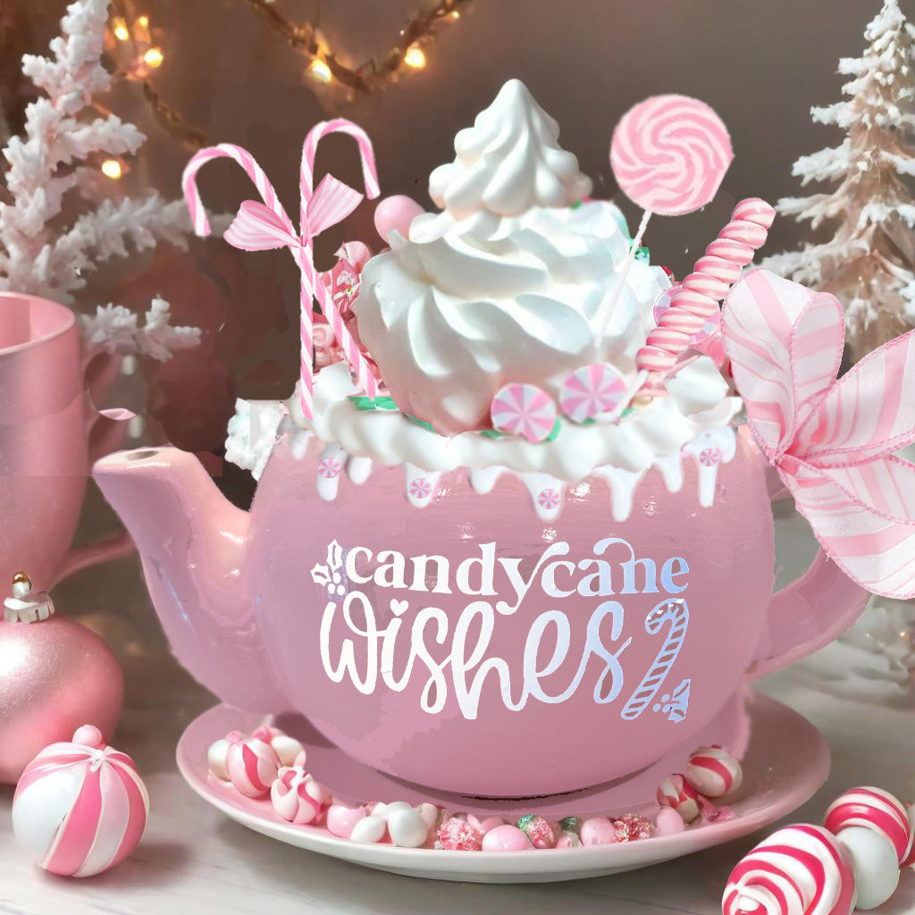 alt= A pink teapot decorated with candy canes and whipped cream, surrounded by Christmas ornaments and peppermint candies. The words "candy cane wishes" are written on the teapot.