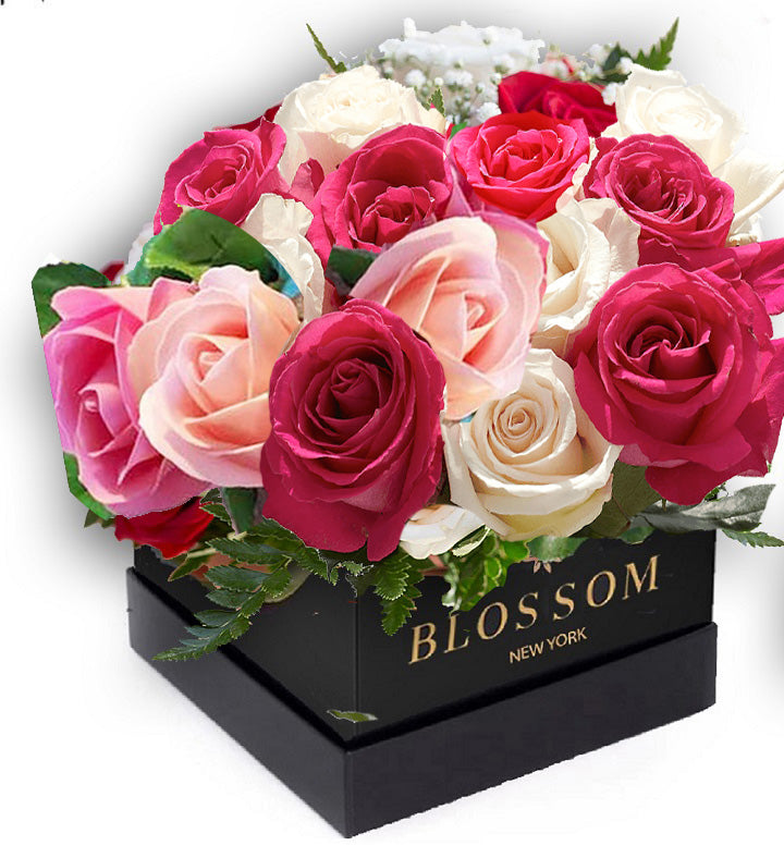 A square black box labeled "Blossom New York" contains a vibrant arrangement of pink, red, and white roses, accented with green leaves and baby's breath.